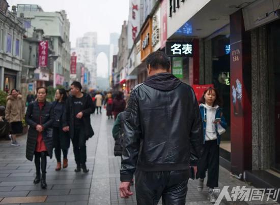 走在溫州市區最繁華的五馬街，經過這些年的“逃犯”生涯，金錦壽的背影顯得有些落寞