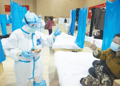 為緩解患者的焦慮情緒，在武漢大學中南醫院隔離病房，河北醫療隊護士用漫畫同患者交流。高翔攝（新華社發）